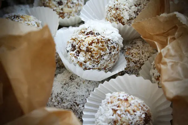Die Aprikosen-Kokos-Bällchen in einer Keksdose mit Backpapier lagern trocken lagern.