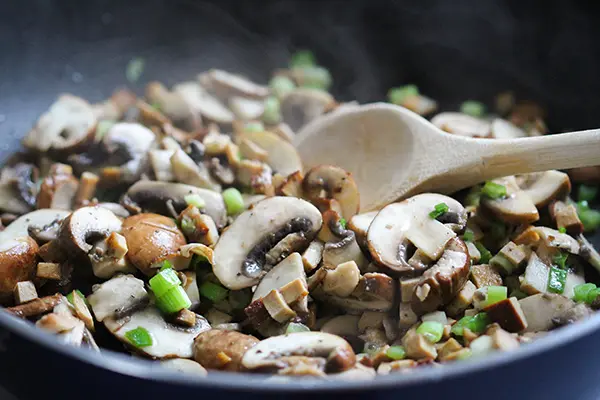 Anbraten der Champignons und Frühlingszwiebeln