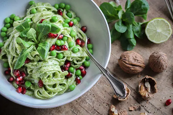Köstlich vegan: Pasta mit Feldsalat-Pesto, Erbsen & Granatapfelkernen