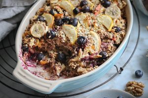 Warmes Ofenporridge mit Äpfeln, Banane und Beeren in einer Auflaufform