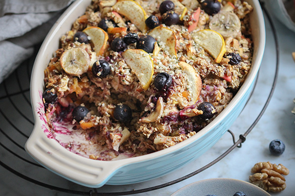 Warmes Ofenporridge mit Äpfeln, Banane und Beeren in einer Auflaufform