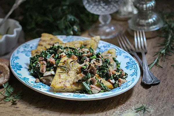 Polenta mit Schwarzkohl auf einem ovalen Teller angerichtet