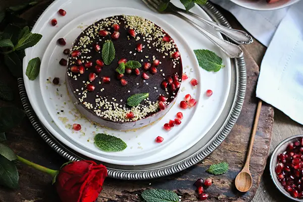Veganer no-bake-cake mit Himbeeren und Granatapfel