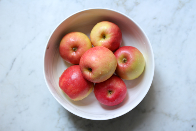 Frische Äpfel, leuchtend rot in einer weißen Schale