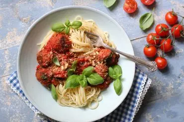 Pasta mit veganen Fleischklösschen auf einem Teller mit Tomatensoße