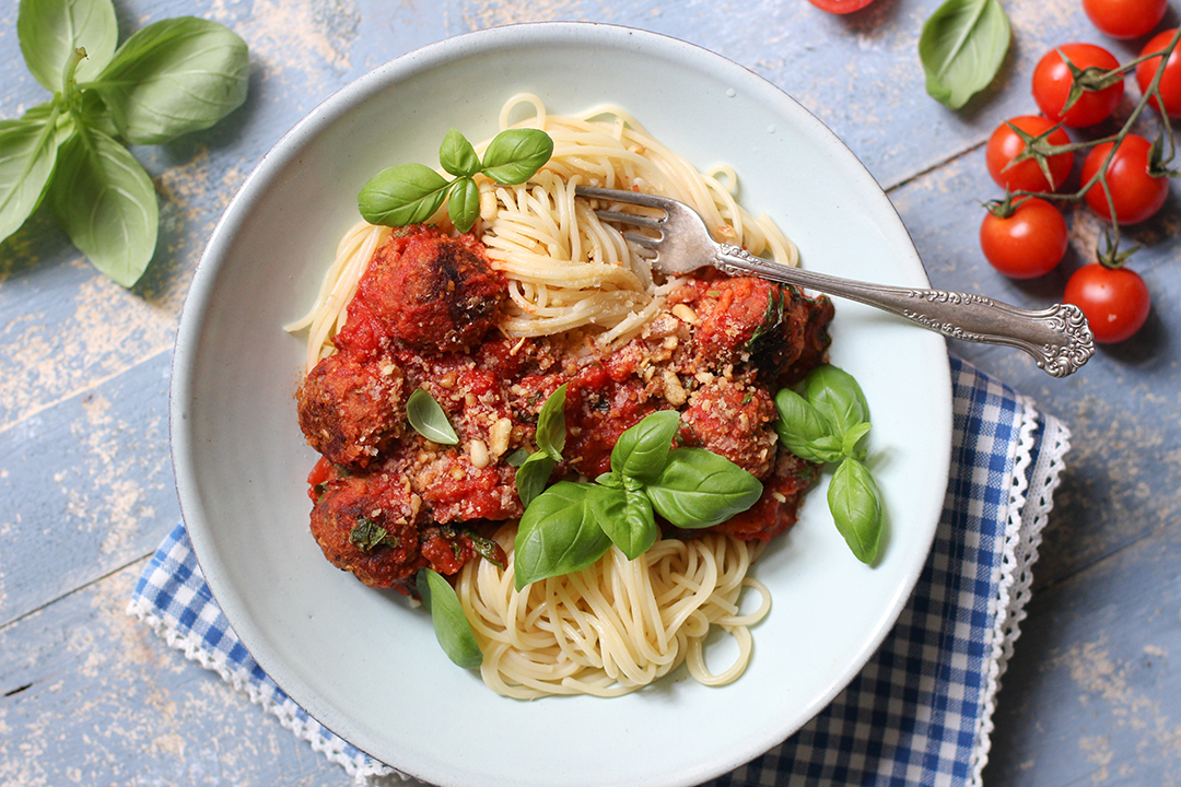 Pasta mit veganen Fleischklösschen auf einem Teller mit Tomatensoße