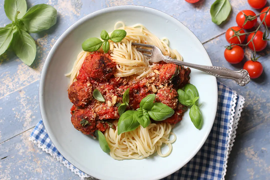 Pasta mit veganen Fleischklösschen auf einem Teller mit Tomatensoße