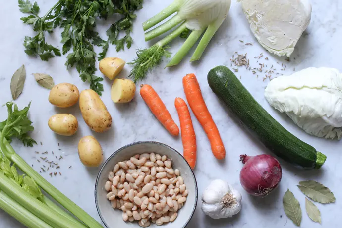 Zutaten für eine vegane Minestrone mit Bohnen, Kohl, Kartoffeln und Fenchel