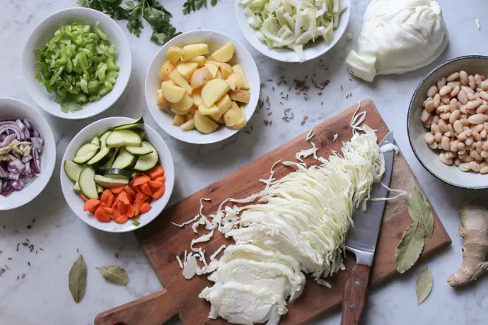 Zutaten für eine vegane Minestrone mit Bohnen, Kohl, Kartoffeln und Fenchel