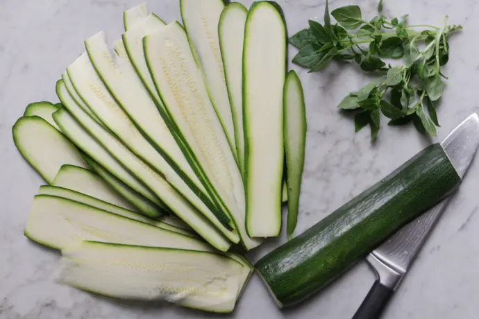 Zucchini in Streifen gehobelt auf einem Marmortisch