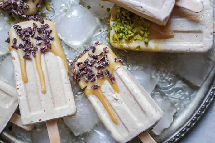 Karamelliges veganes Eis am Stiel mit Kakaonibs und Pistazien