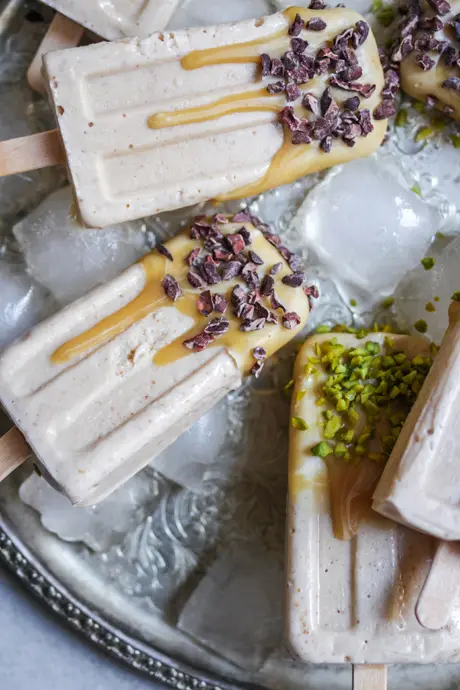 Karamelliges veganes Eis am Stiel mit Kakaonibs und Pistazien