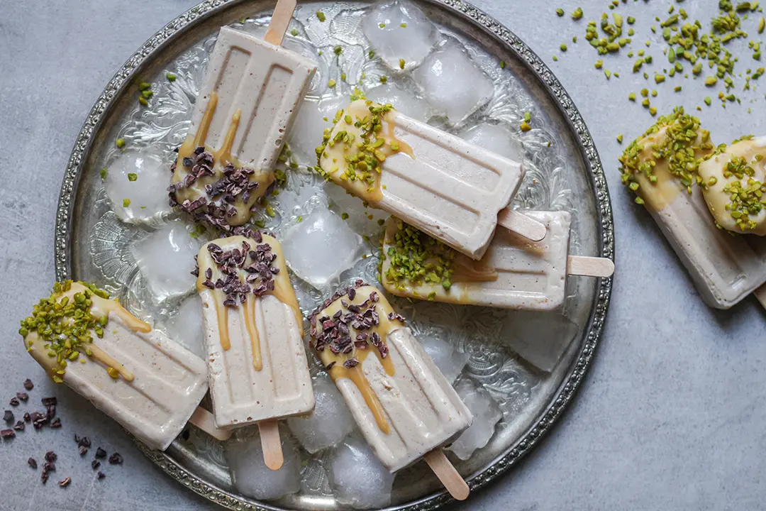 Karamelliges veganes Eis am Stiel mit Kakaonibs und Pistazien