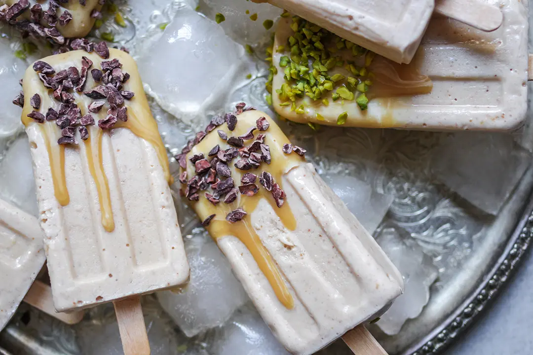Karamelliges veganes Eis am Stiel mit Kakaonibs und Pistazien