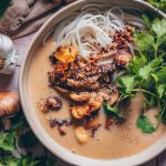 Vegane Miso-Pilzsuppe mit Reisbandnudeln in einer Suppenschale mit Koriander angerichtet