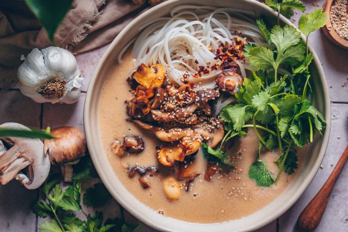 Vegane Miso-Pilzsuppe mit Reisbandnudeln in einer Suppenschale mit Koriander angerichtet