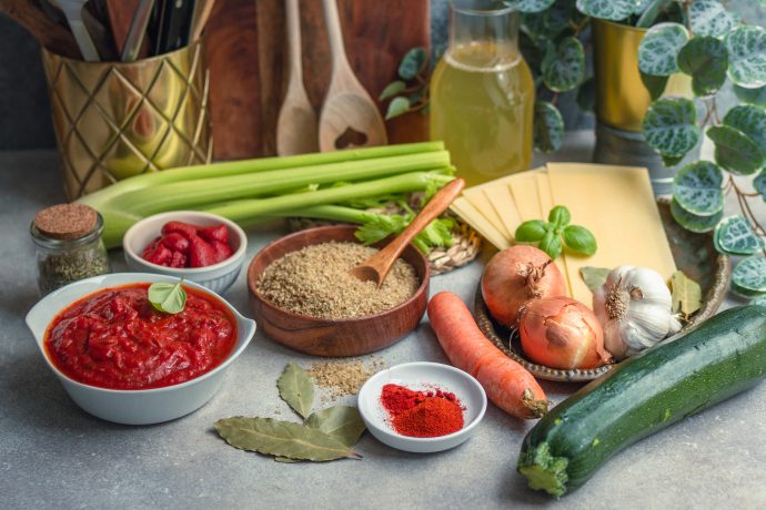 Zutaten für eine vegane Lassagnesuppe: Grünkern, Sellerie, Karotten, Zucchini, Tomatensoße und Gewürze