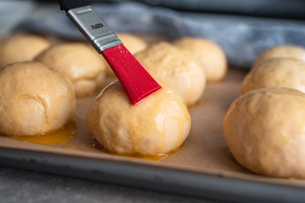 Teiglinge für Ofen-Berliner mit zerlassener Butter bepinseln