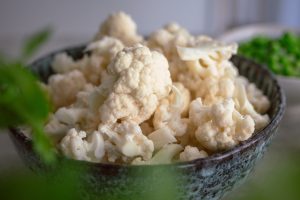 Blumenkohl in einer blauen Keramikschale in Röschen gebrochen