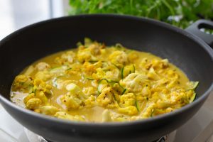 Zutaten für das vegane Madras-Curry köcheln in einem Wok