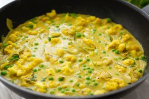 Veganes Madras-Curry köchelt in einem Wok