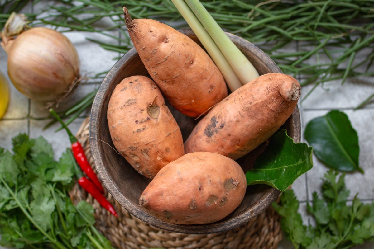 Vier frische Süßkartoffeln in einer Holzschale - Vorbereitung Süßkartoffelsuppe