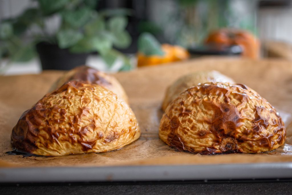 Gebackener Butternut-Kürbis mit Schale, halbiert auf einem Backblech