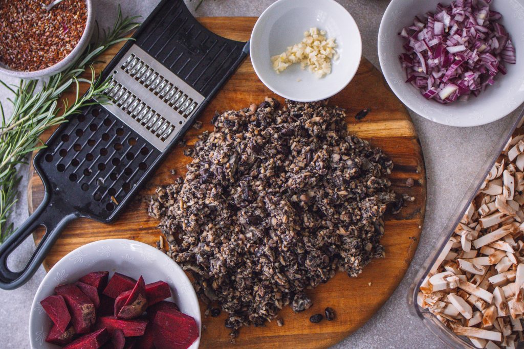 Zutaten für die Füllung des veganen Tempeh-Weihnachtsbratens in mehreren Schüsseln auf einer Arbeitsfläche