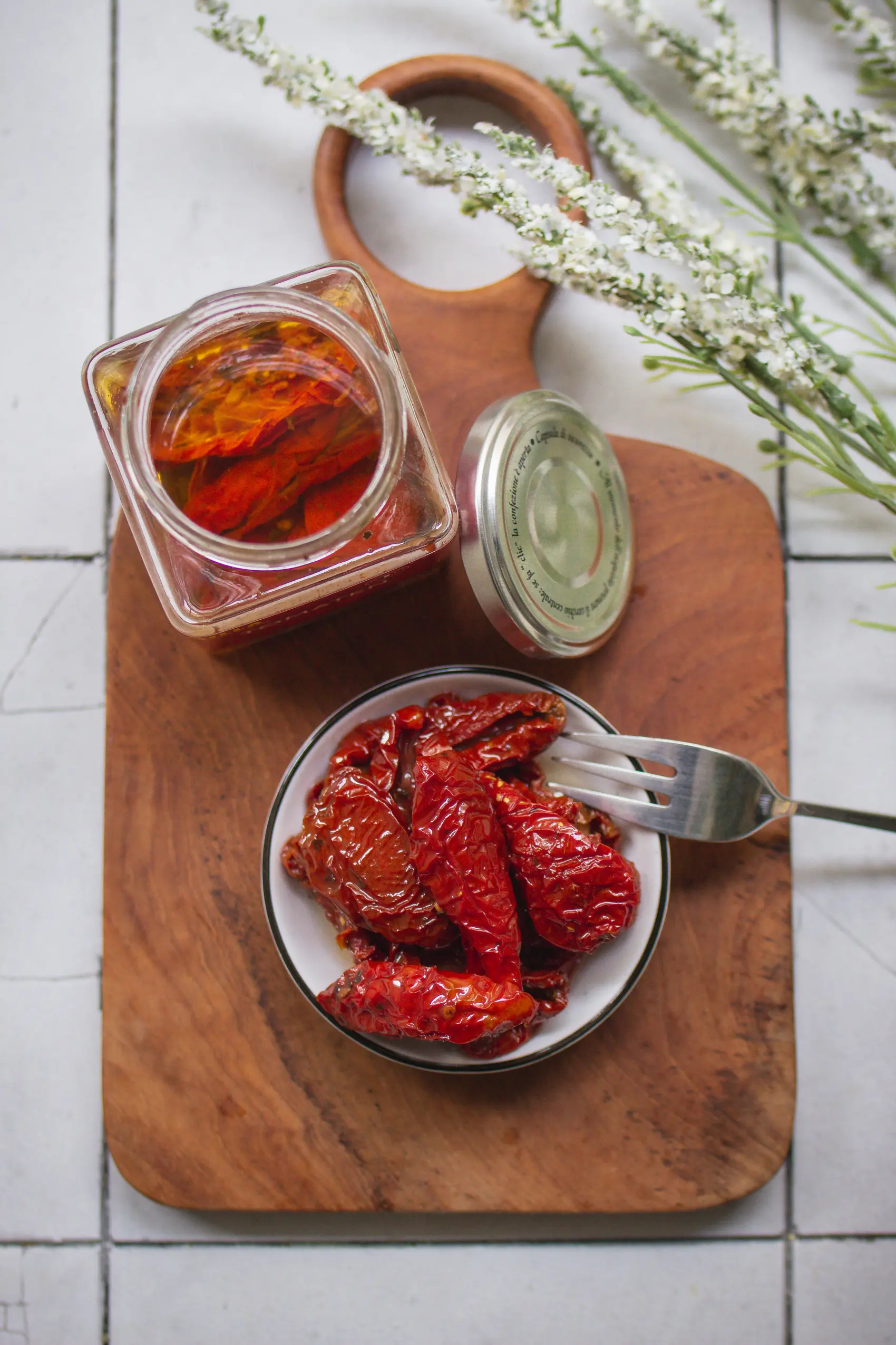 Getrocknete, in öl eingelegte Tomaten in einem Glas und einer kleinen Schale