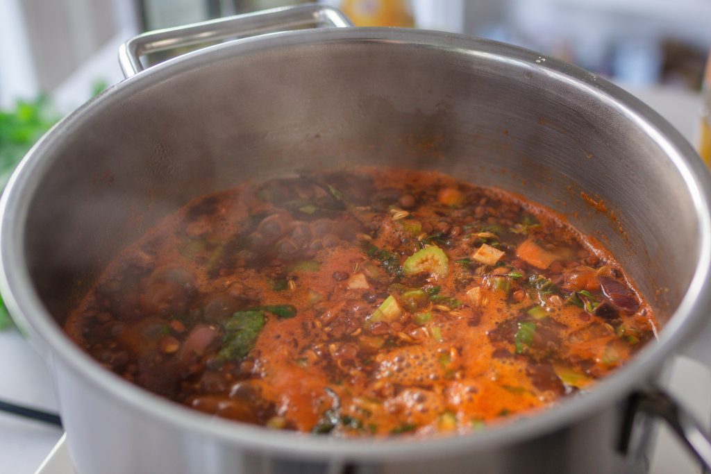 Veganer Berglinseneintopf köchelt in einem Topf von Fissler