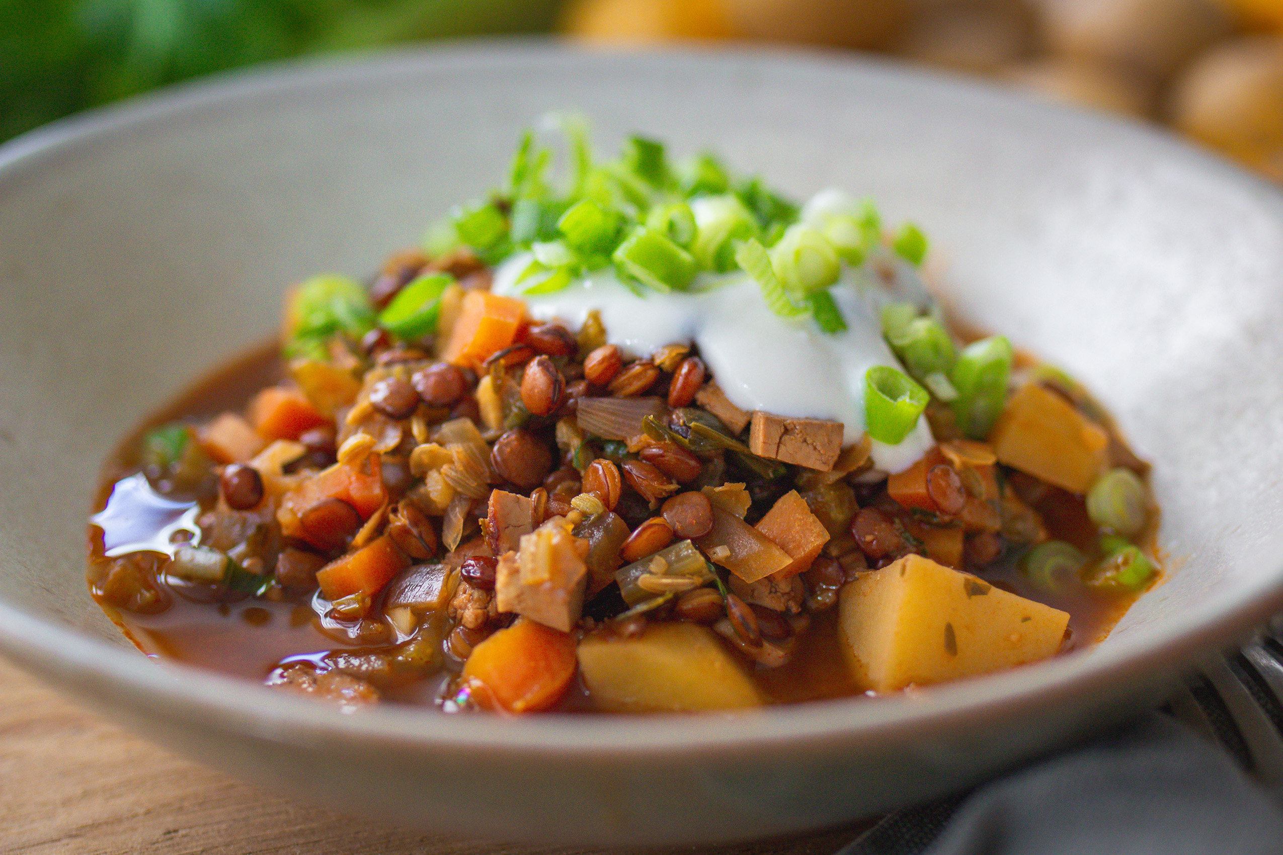 Veganer Berglinseneintopf mit Räuchertofu und Wurzelgemüse in einer Schale angerichtet