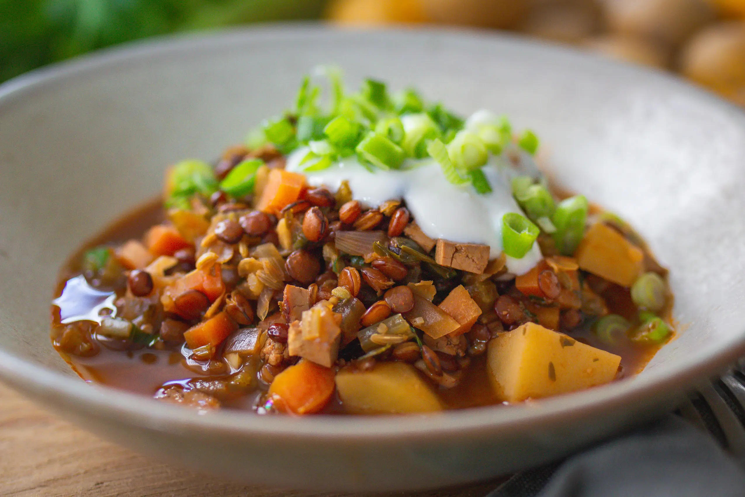 Veganer Berglinseneintopf mit Räuchertofu und Wurzelgemüse in einer Schale angerichtet