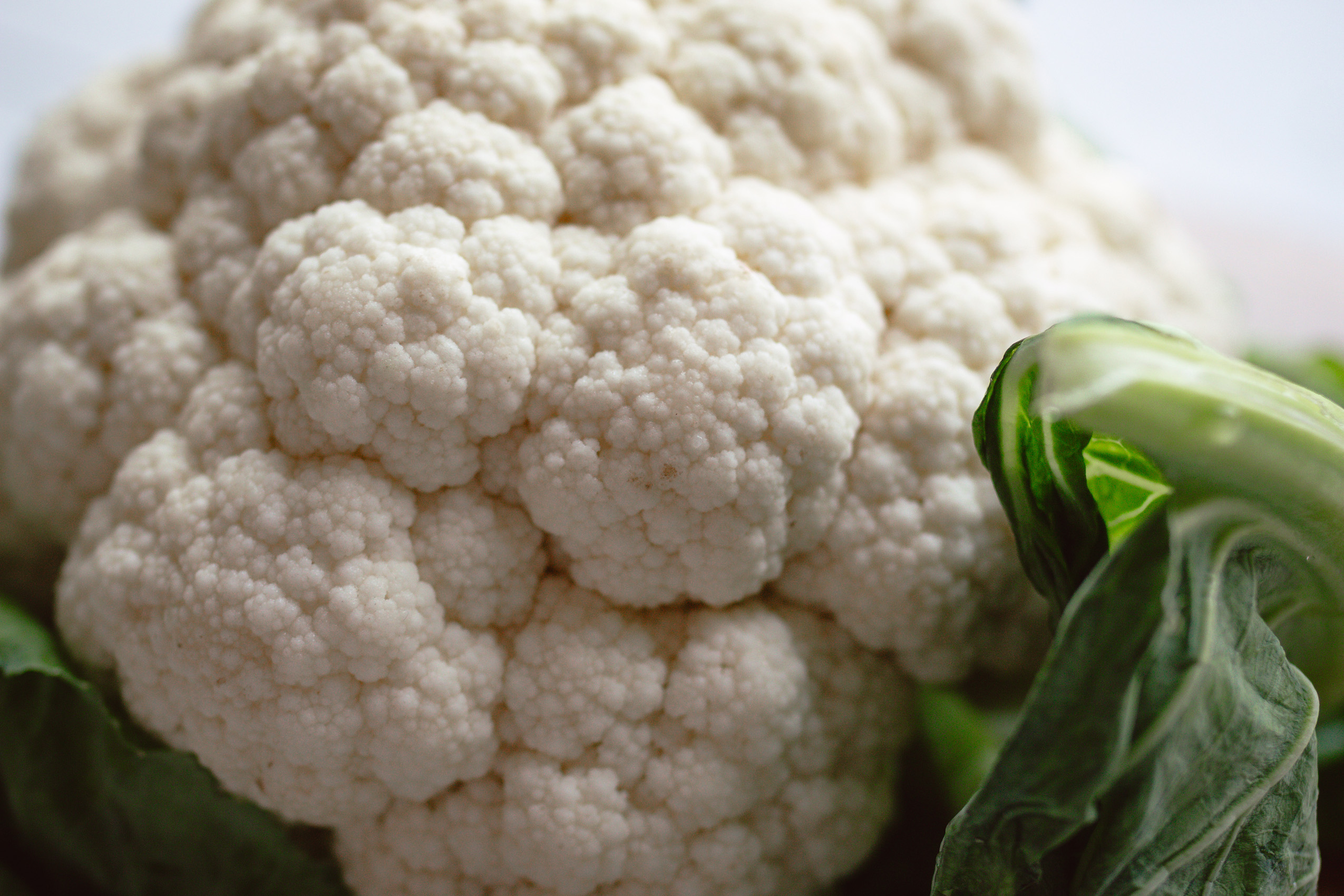 Nahe Aufnahme eines frischen Blumenkohls mit saftigen Blättern