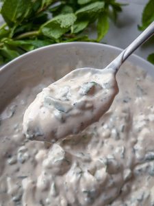 Veganer Quarkdip mit frischer Minze nahaufnahme mit einem Löffel Dip