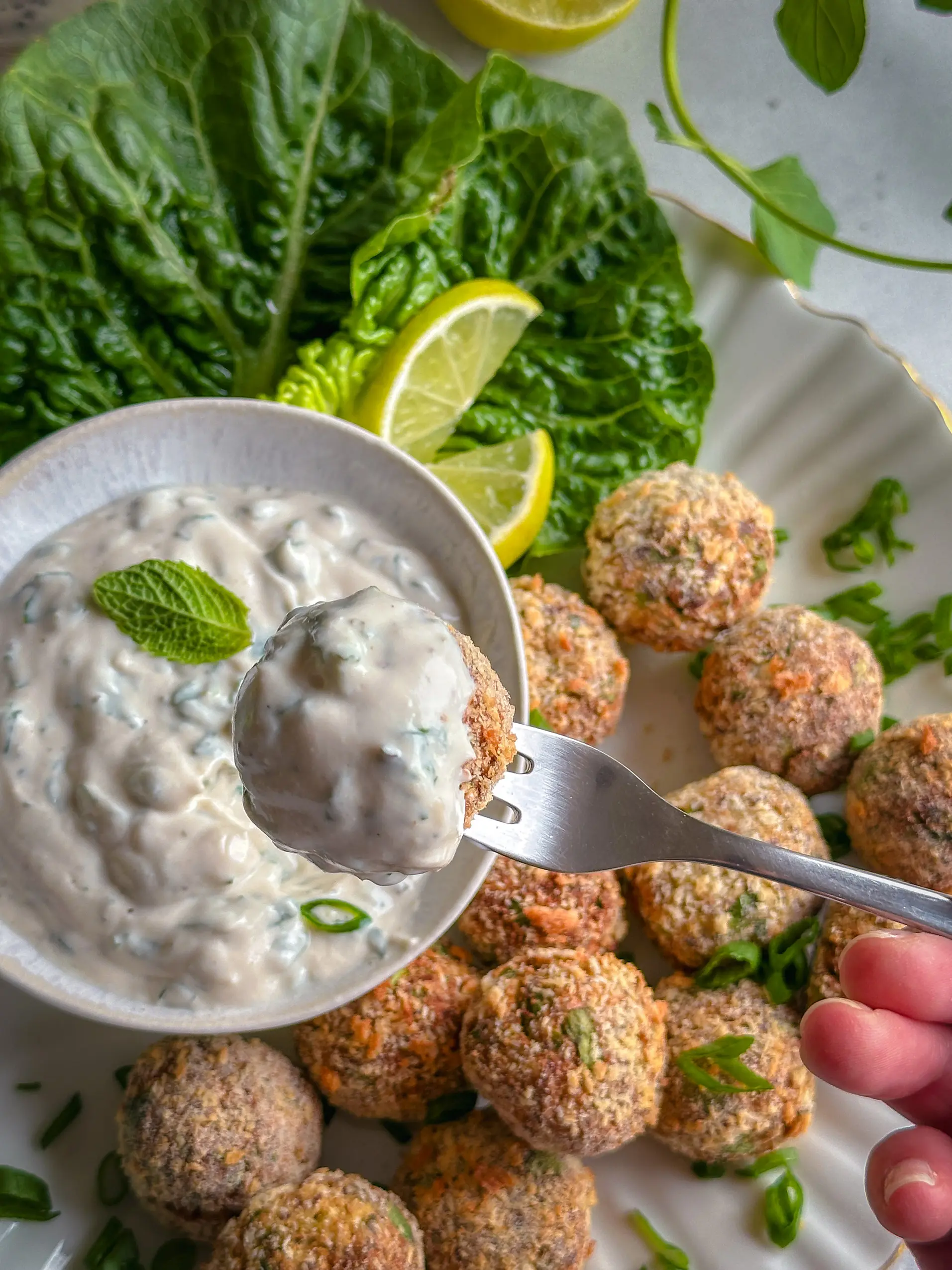 Vegane knusprige Blumenkohl-Quark-Arancini auf einem Teller mit Dip