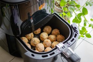 Vegane knusprige Blumenkohl-Quark-Arancini auf einem Teller mit Dip