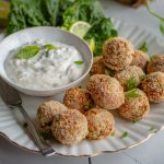 Vegane knusprige Blumenkohl-Quark-Arancini auf einem Teller mit Dip
