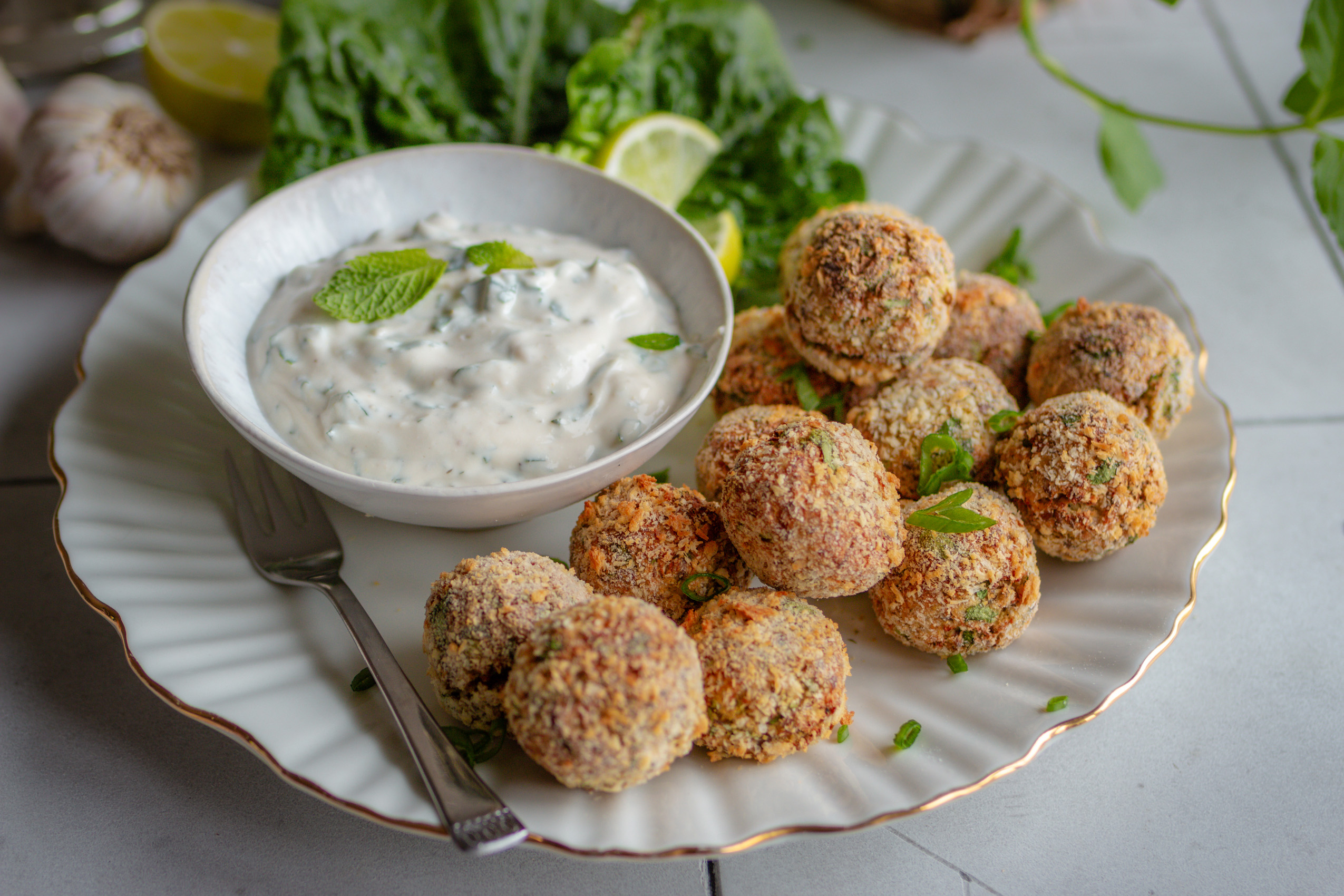 Vegane knusprige Blumenkohl-Quark-Arancini auf einem Teller mit Dip