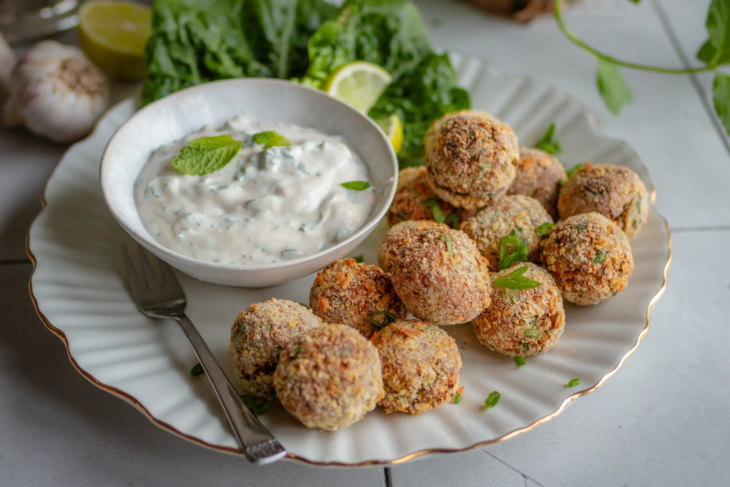 Vegane knusprige Blumenkohl-Quark-Arancini auf einem Teller mit Dip