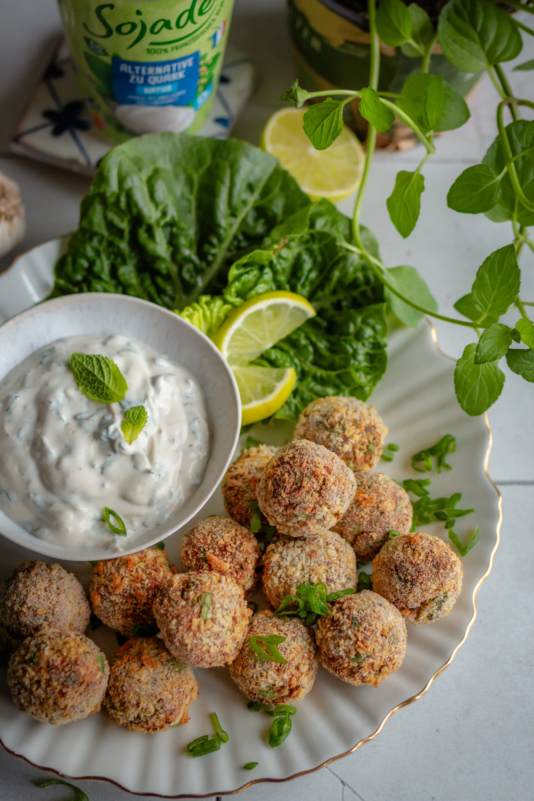 Vegane knusprige Blumenkohl-Quark-Arancini auf einem Teller mit Dip