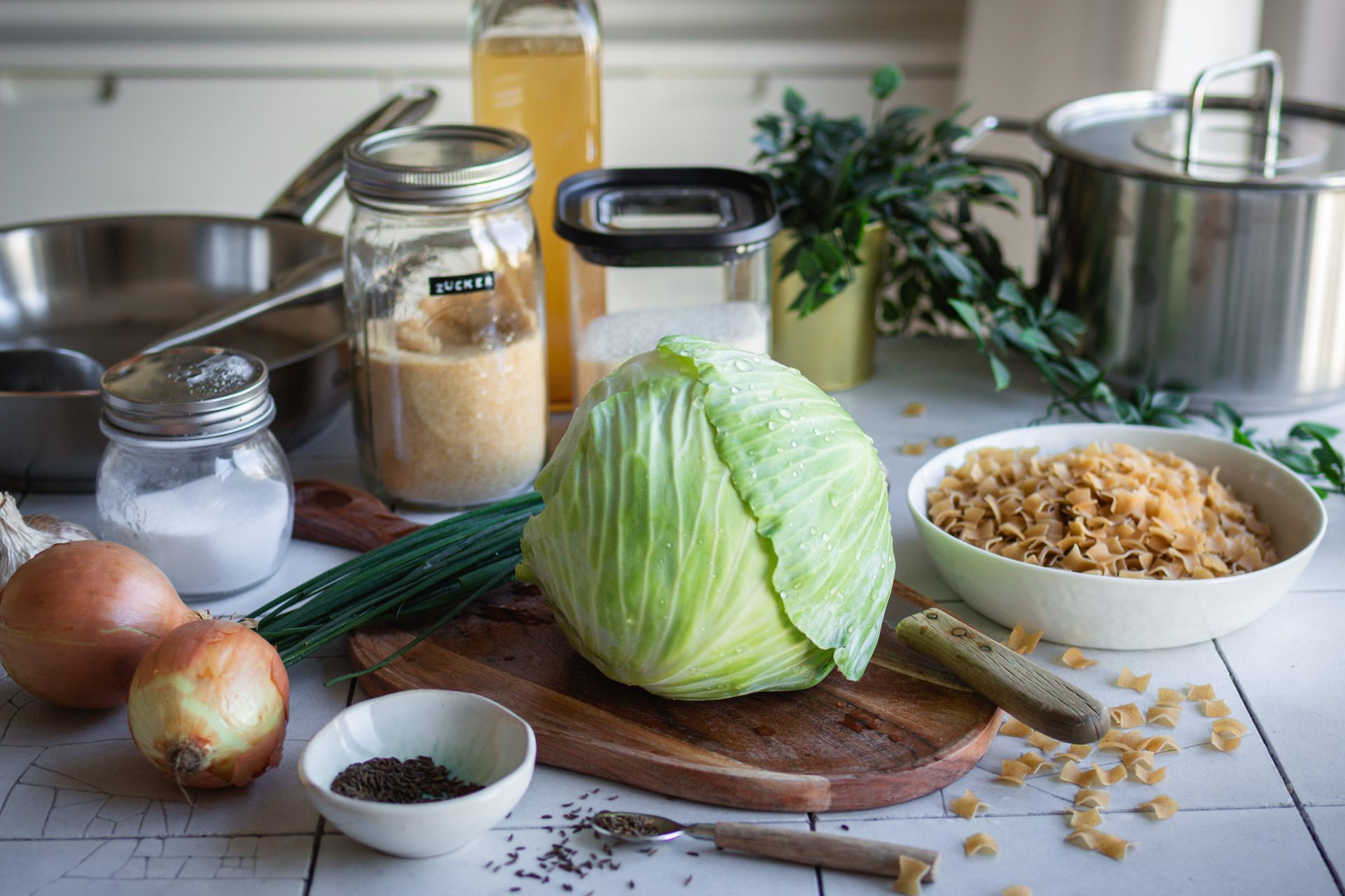 Weißkohl, Fleckerlnudeln und weitere Zutaten für vegane "Krautfleckerl" auf einem Küchentisch