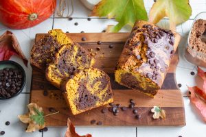 Veganer Kürbis-Schokokuchen auf einem Holzbrett angeschnitten