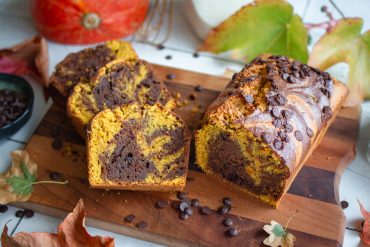 Veganer Kürbis-Schokokuchen angerichtet und aufgeschnitten auf einem Brettchen