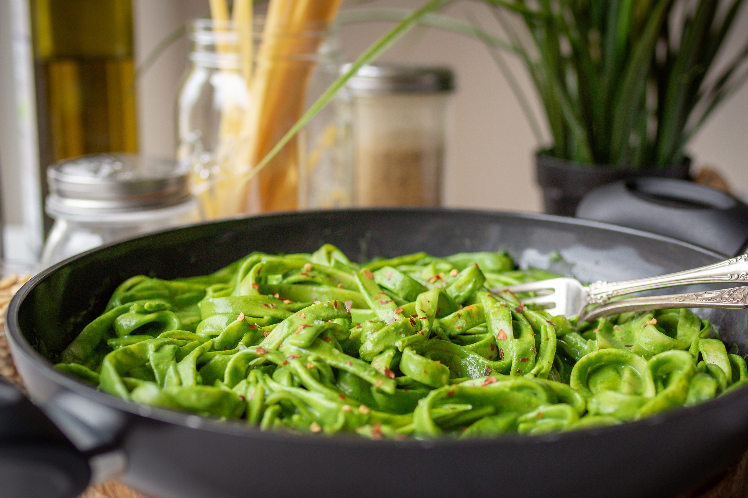 Vegane leuchtend grüne Schwarzkohl-Pasta in einer Servierpfanne angerichtet